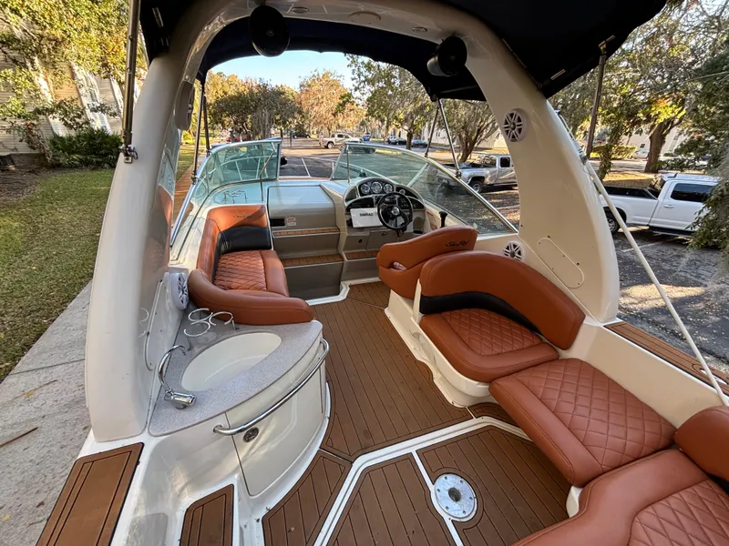 Slide: The Image of 2005 Sea Ray 260 Sundancer boat interior with brown leather seating and wood flooring. - 13