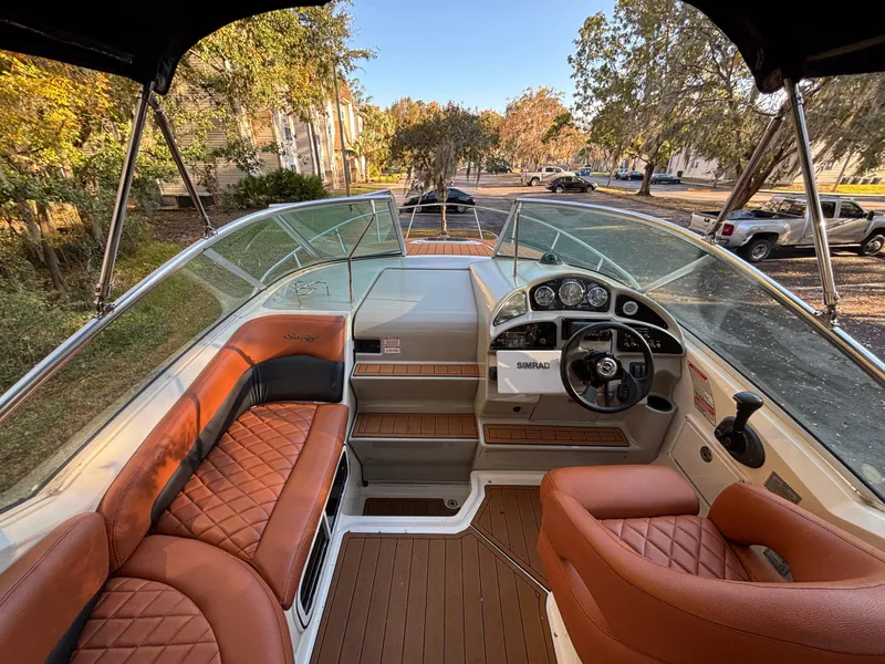 Slide: The Image of 2005 Sea Ray 260 Sundancer boat interior with brown leather seats and steering console. - 14