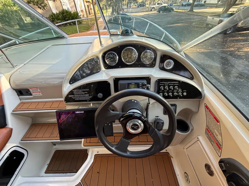 Slide: The Image of 2005 Sea Ray 260 Sundancer boat dashboard with steering wheel and control panel. - 15