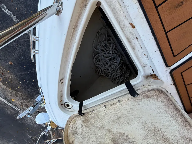 Slide: The Image of Open storage compartment on 2005 Sea Ray 260 Sundancer boat with coiled rope inside. - 19
