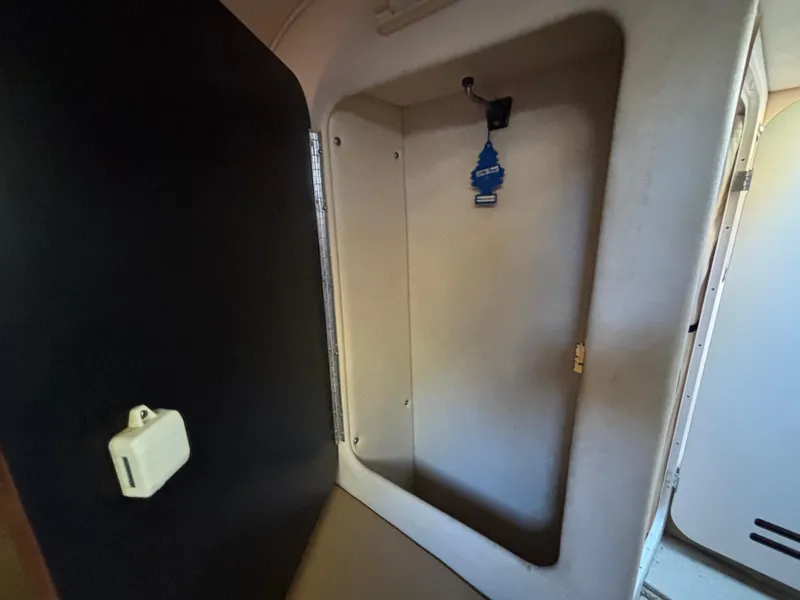 Slide: The Image of 2005 Sea Ray 260 Sundancer cabin interior with storage compartment and air freshener. - 28