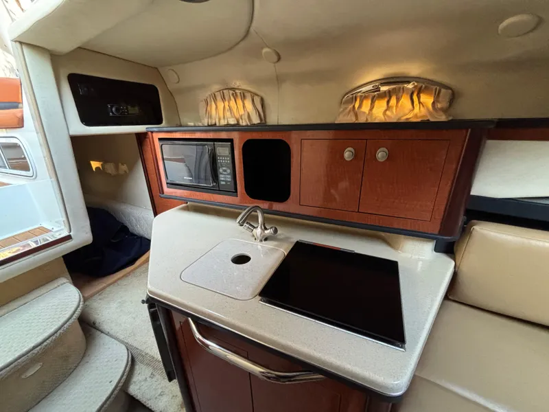 Slide: The Image of 2005 Sea Ray 260 Sundancer cabin with kitchenette, sink, and microwave. - 29