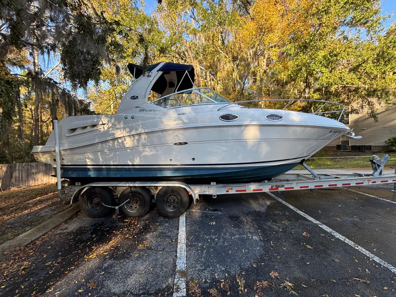 Slide: The Image of 2005 Sea Ray 260 Sundancer boat on trailer, parked in wooded area. - 3