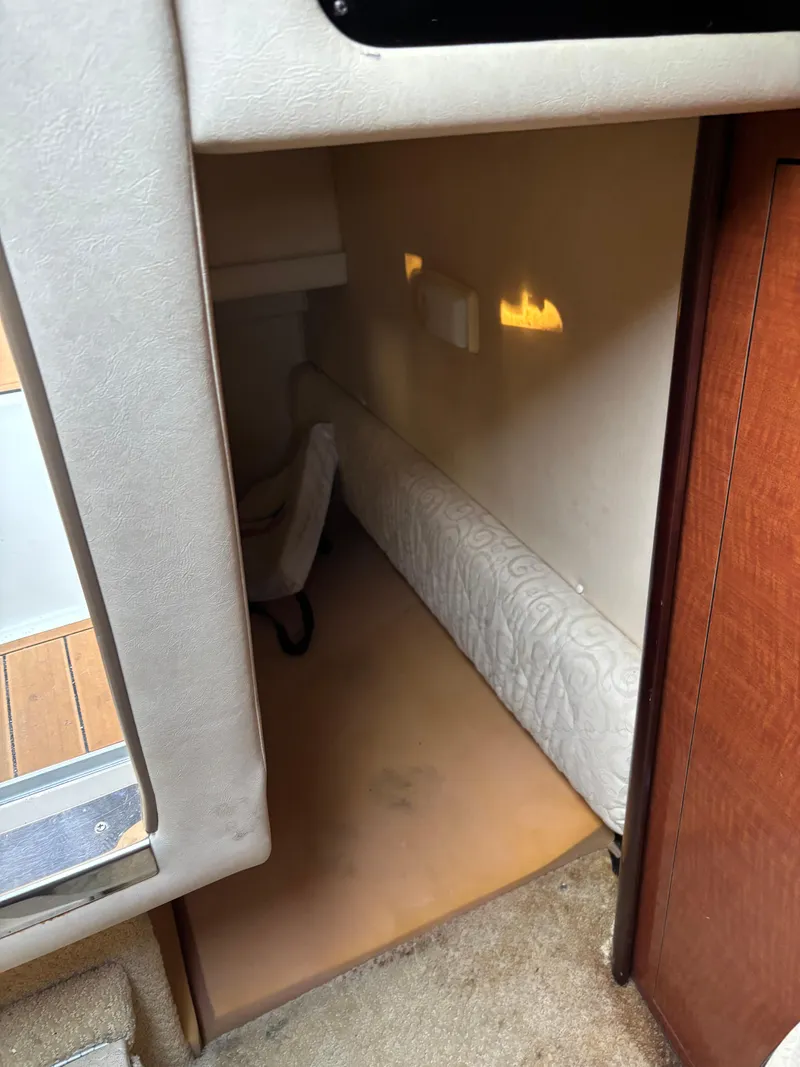 Slide: The Image of 2005 Sea Ray 260 Sundancer cabin interior with cushioned seating and wooden accents. - 34
