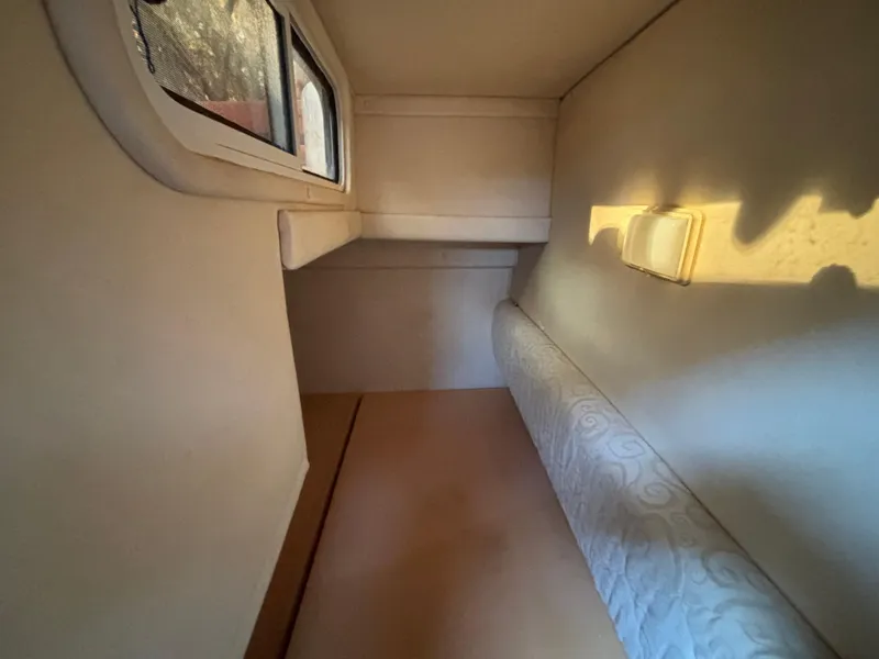 Slide: The Image of 2005 Sea Ray 260 Sundancer cabin interior with window and cushioned seating. - 35