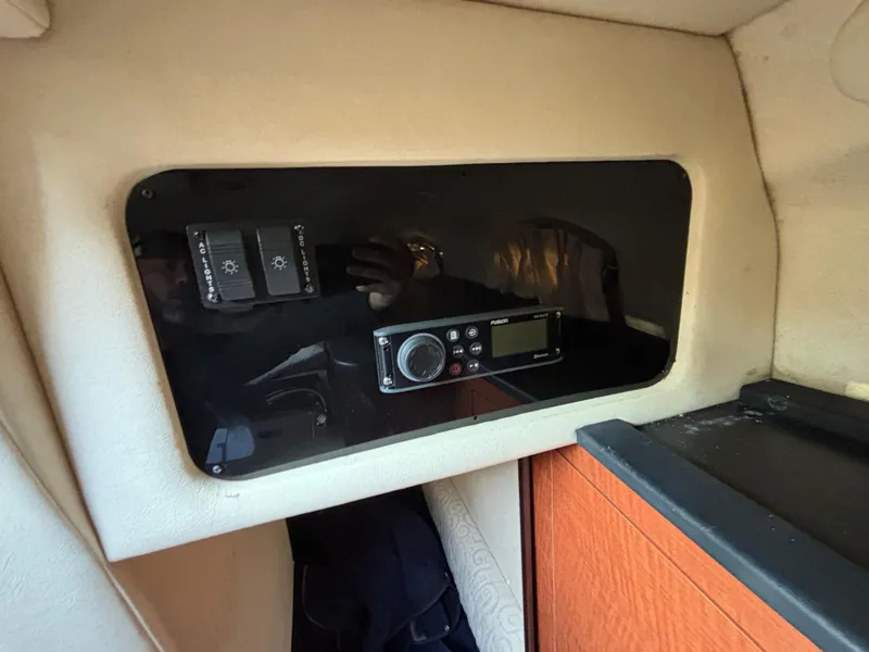 Slide: The Image of 2005 Sea Ray 260 Sundancer cabin interior with control panel and radio system. - 38