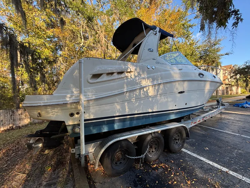 Slide: The Image of 2005 Sea Ray 260 Sundancer boat on trailer, parked outdoors in a wooded area. - 4