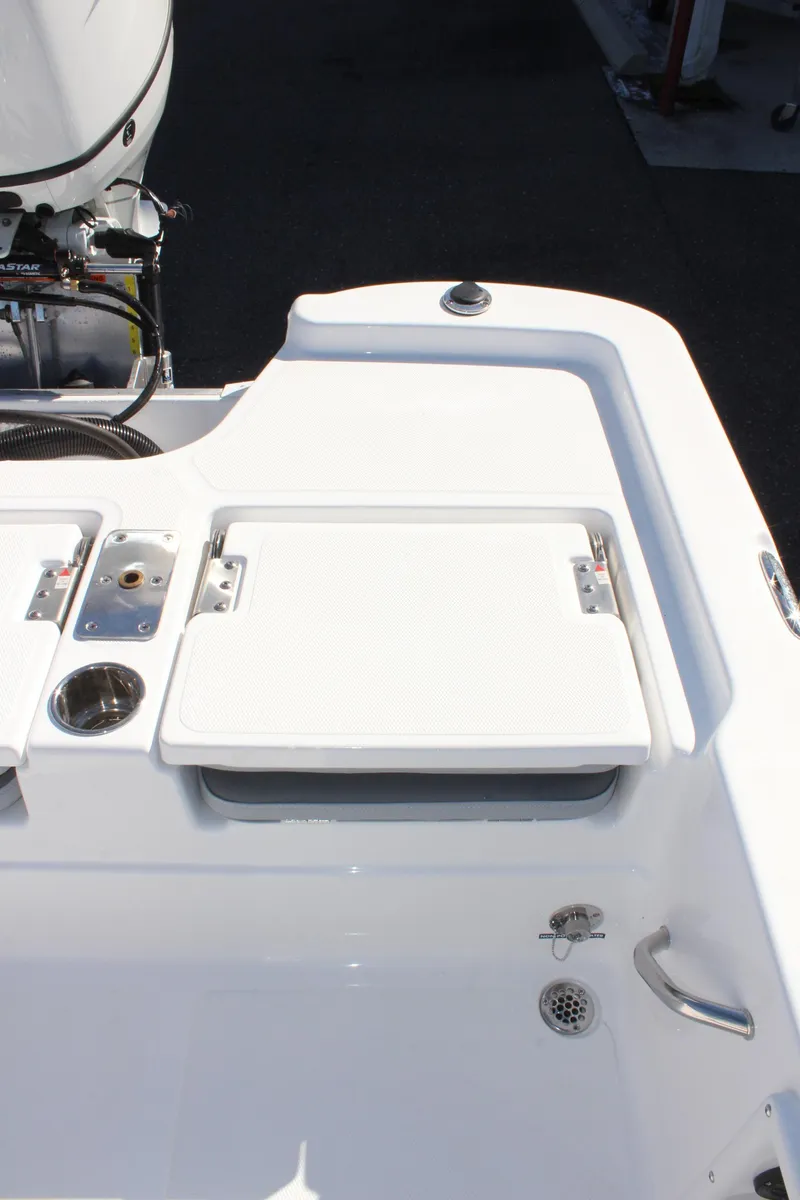 Slide: The Image of 2025 NauticStar 214 Shallow Bay boat deck with storage compartment and motor. - 12