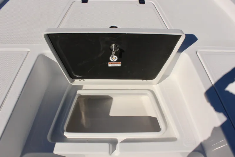 Slide: The Image of 2025 NauticStar 214 Shallow Bay storage compartment with open hatch and key. - 23