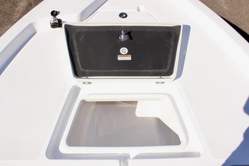 Slide: The Image of 2025 NauticStar 214 Shallow Bay boat storage compartment, open lid, white interior. - 24
