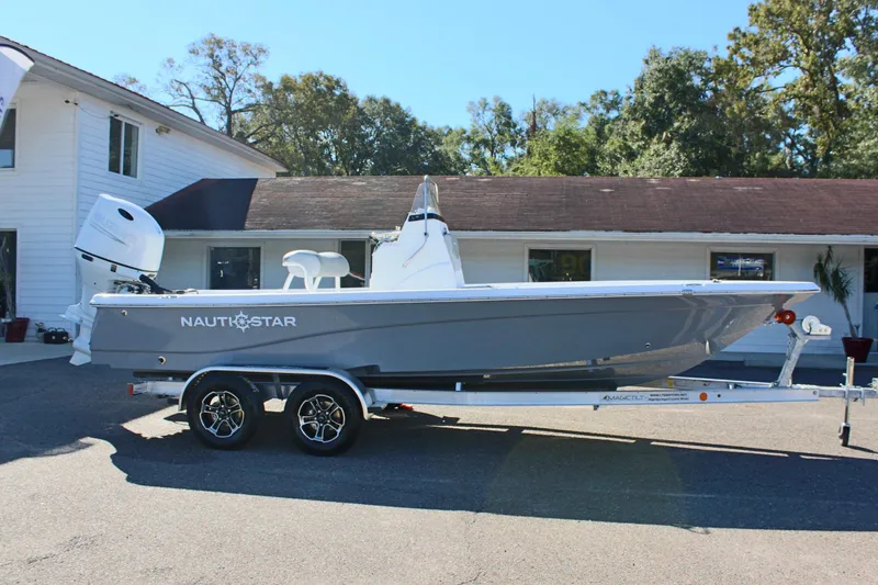 Slide: The Image of 2025 NauticStar 214 Shallow Bay boat on trailer, parked outside a building. - 6