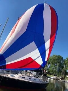 Slide: The Image of 1988 Tartan 31 sailboat with colorful spinnaker in marina setting. - 11