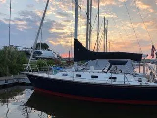 Slide: The Image of 1988 Tartan 31 sailboat docked at sunset with colorful sky. - 13