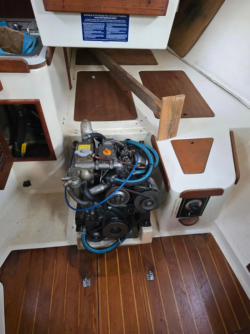 Slide: The Image of Engine compartment of a 1988 Tartan 31 sailboat with visible engine and wooden flooring. - 17