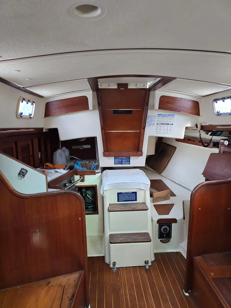 Slide: The Image of Interior of a 1988 Tartan 31 sailboat, featuring wooden cabinetry and compact living space. - 18