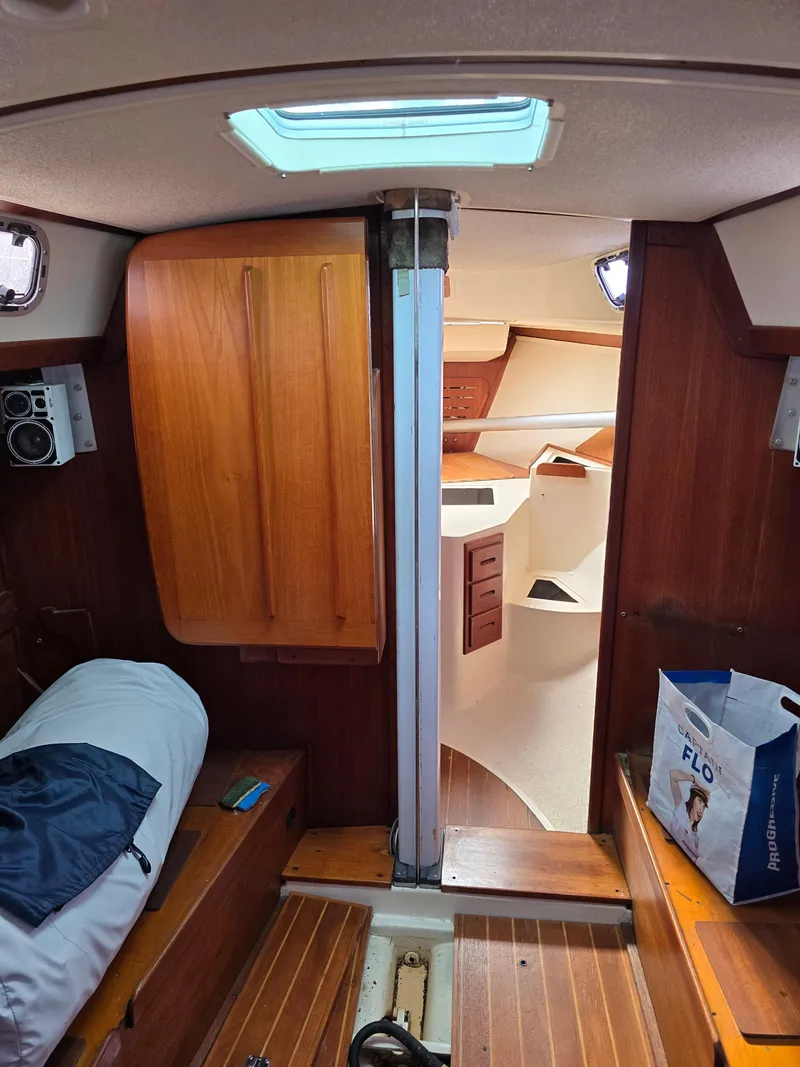 Slide: The Image of Interior of a 1988 Tartan 31 sailboat, featuring wooden cabinetry and cozy sleeping quarters. - 22