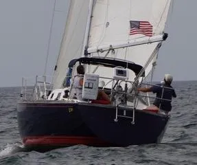 Slide: The Image of Sailing yacht Tartan 31 (1988) with American flag on open sea. - 4