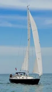 Slide: The Image of 1988 Tartan 31 sailboat on open water under clear blue sky. - 9