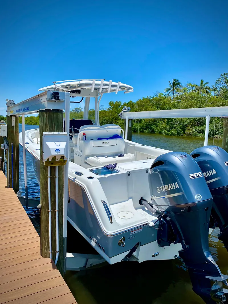Slide: The Image of 2017 Sea Hunt Gamefish 27 boat with dual Yamaha engines docked on a sunny day. - 2