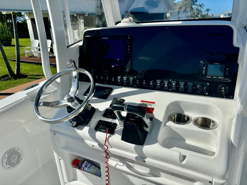 Slide: The Image of 2017 Sea Hunt Gamefish 27 helm with steering wheel, controls, and navigation equipment. - 7