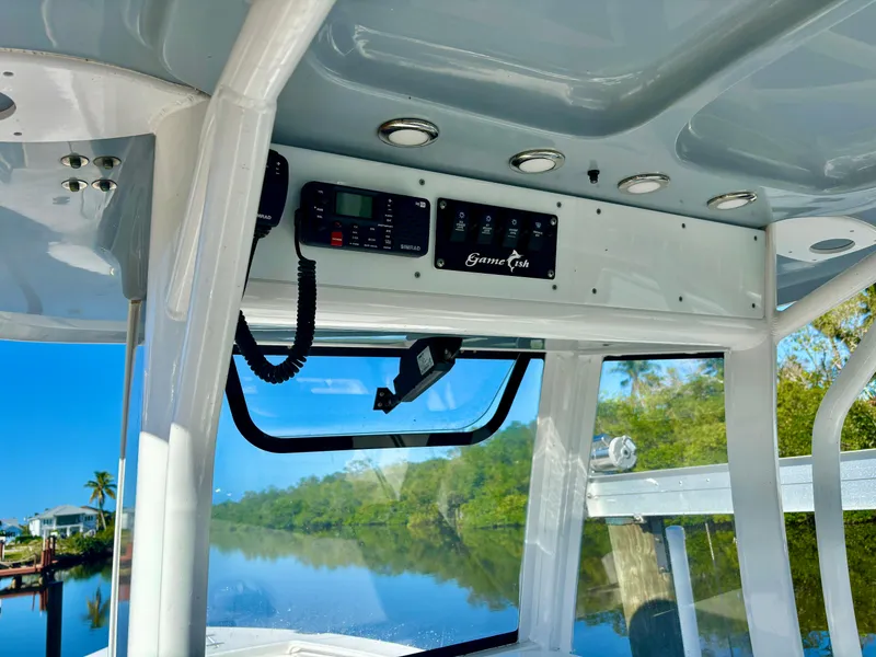Slide: The Image of 2017 Sea Hunt Gamefish 27 boat interior with control panel, overlooking serene waterway. - 8