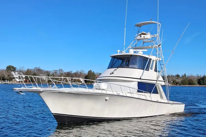 The Image of 1992 Henriques 50 Sportfisherman boat on calm water under clear blue sky. - 0