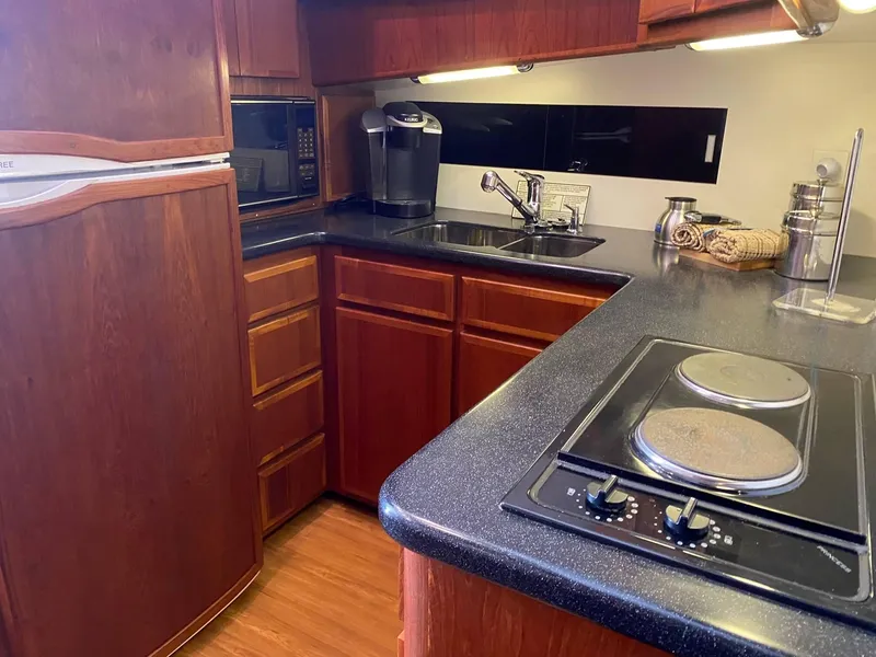 Slide: The Image of 1992 Henriques 50 Sportfisherman kitchen with wood cabinets, stove, and sink. - 16