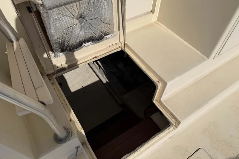 Slide: The Image of 1992 Henriques 50 Sportfisherman engine compartment access hatch, open with visible insulation. - 22