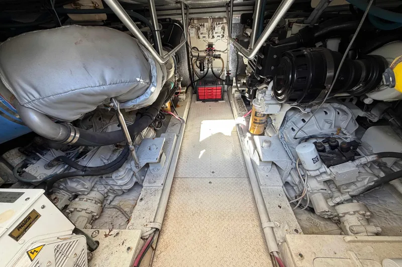 Slide: The Image of Engine room of a 1992 Henriques 50 Sportfisherman, showcasing dual engines and mechanical components. - 23