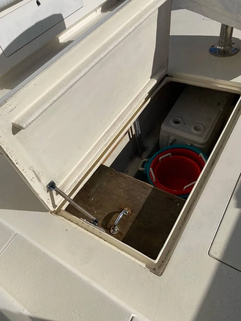 Slide: The Image of Open storage compartment on 1992 Henriques 50 Sportfisherman boat with bucket and cooler. - 7
