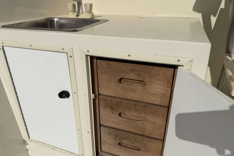 Slide: The Image of 1992 Henriques 50 Sportfisherman interior with sink and wooden storage drawers. - 9