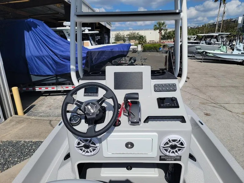 Slide: The Image of 2025 SCB R24 boat console with steering wheel, controls, and speakers in a marina setting. - 10