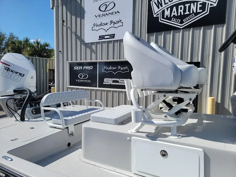 Slide: The Image of 2025 SCB R24 boat with white seating and engine, displayed at a marine sales service. - 6