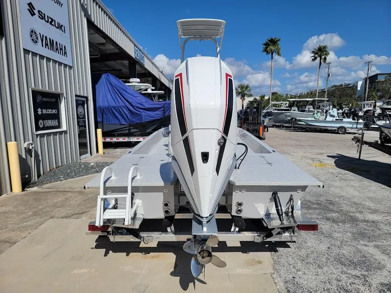 Slide: The Image of 2025 SCB R24 boat at dealership, rear view with outboard motor, sunny day. - 8