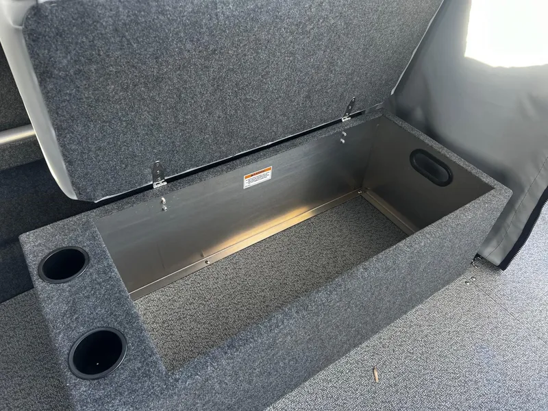 Slide: The Image of 2025 Thunder Jet 185 Luxor storage compartment with cup holders and carpeted interior. - 13