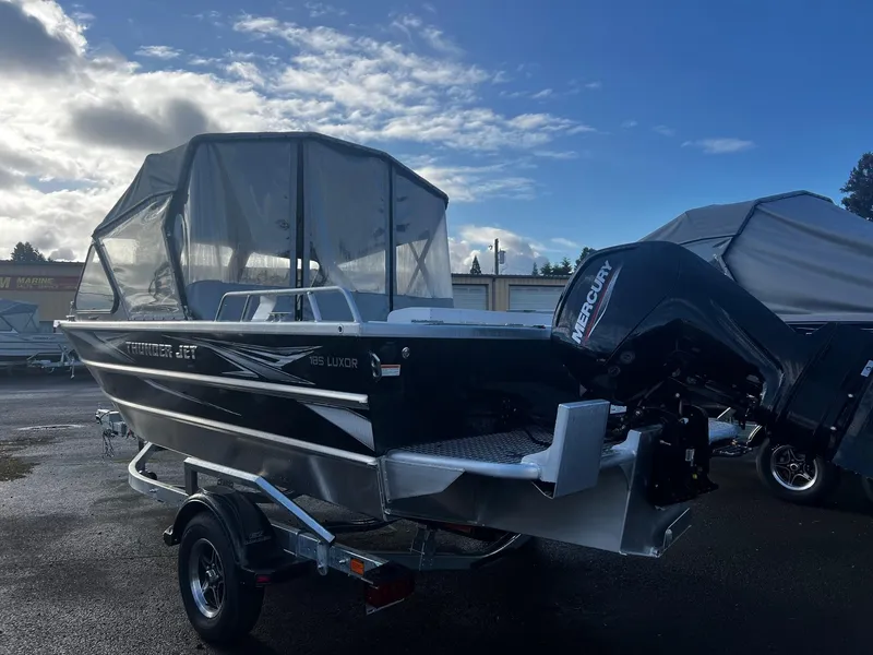 Slide: The Image of 2025 Thunder Jet 185 Luxor boat with Mercury engine on trailer, under cloudy sky. - 4
