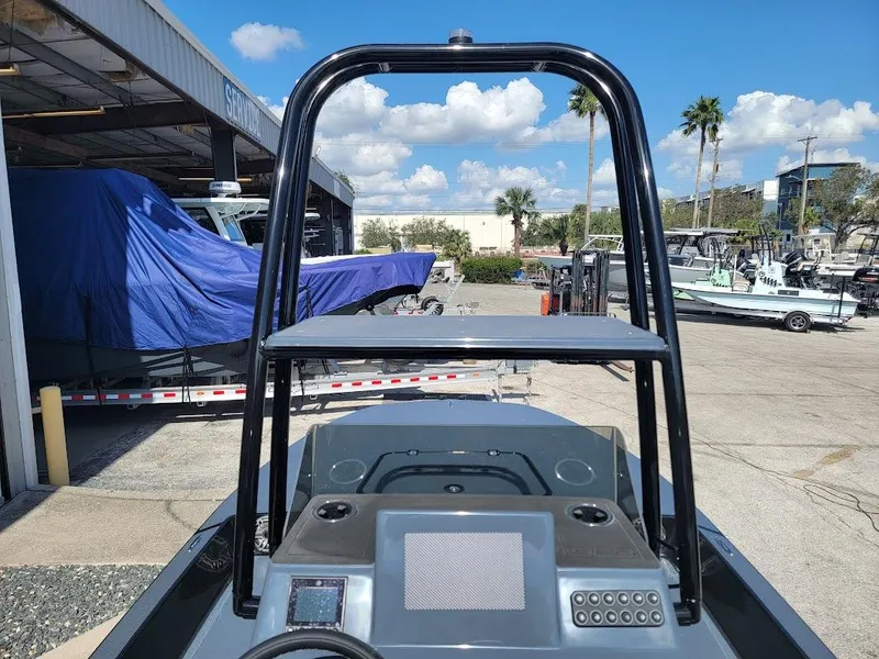 Slide: The Image of 2025 SCB S22 boat console with T-top, docked under clear blue sky. - 19