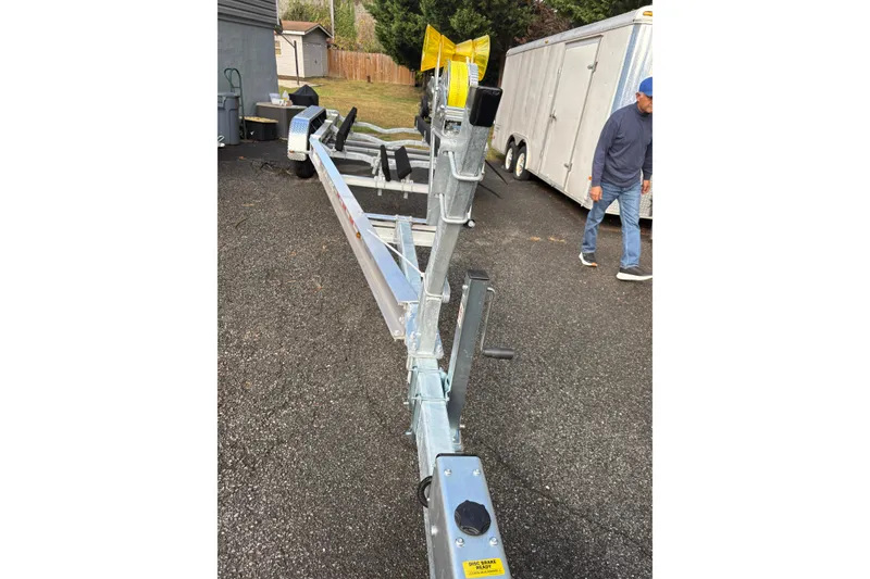 Slide: The Image of Boat trailer for 2000 Sport-Craft 272 Sportfish on asphalt, with person nearby. - 13