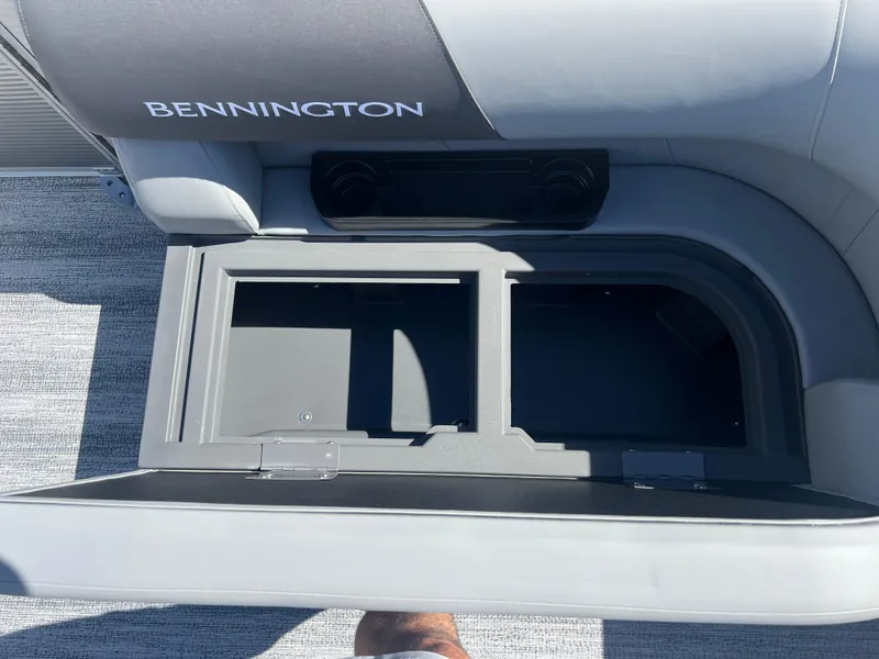 Slide: The Image of 2025 Bennington 20 SL boat storage compartment with open lid, showcasing interior space. - 11