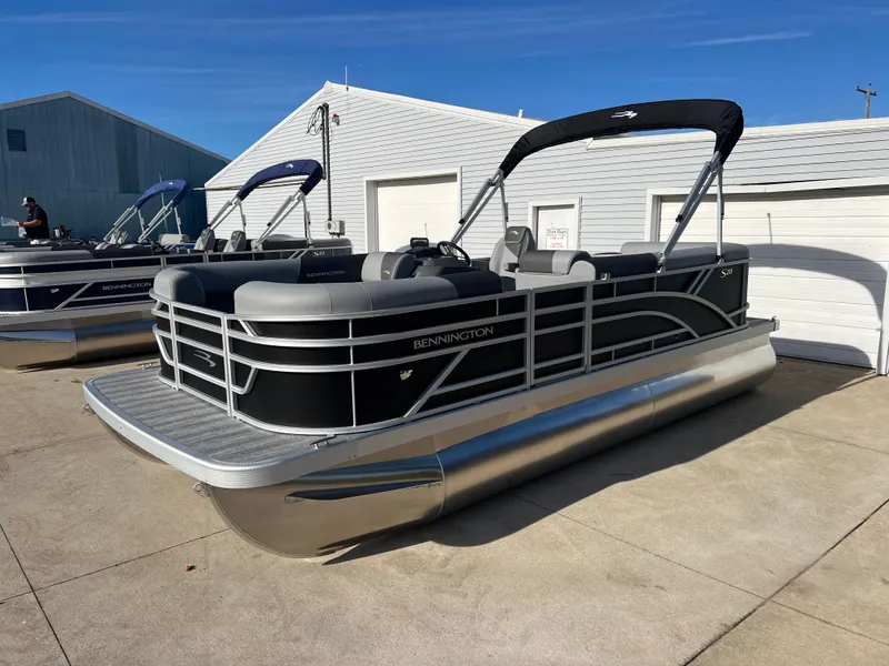 Slide: The Image of 2025 Bennington 20 SL pontoon boat with sleek design, parked outdoors. - 3