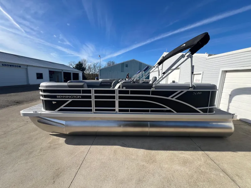 Slide: The Image of 2025 Bennington 20 SL pontoon boat with sleek design, parked outdoors. - 4
