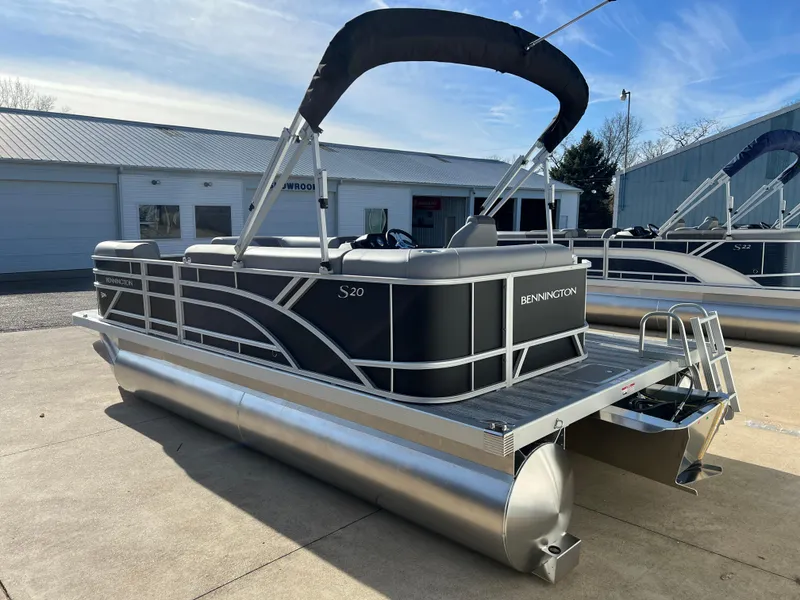 Slide: The Image of 2025 Bennington 20 SL pontoon boat with canopy, parked outdoors. - 5