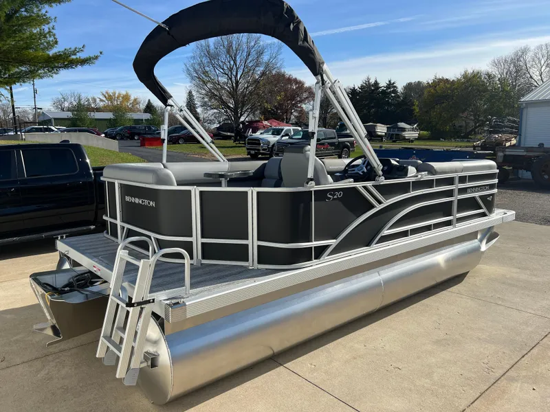 Slide: The Image of 2025 Bennington 20 SL pontoon boat with canopy, parked outdoors. - 7