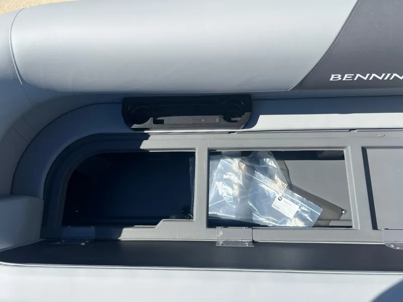 Slide: The Image of 2025 Bennington 20 SL boat seat storage compartment with visible contents. - 9