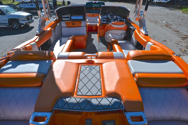 Slide: The Image of 2015 MasterCraft X23 boat interior with orange and white seating, showcasing luxury and comfort. - 18