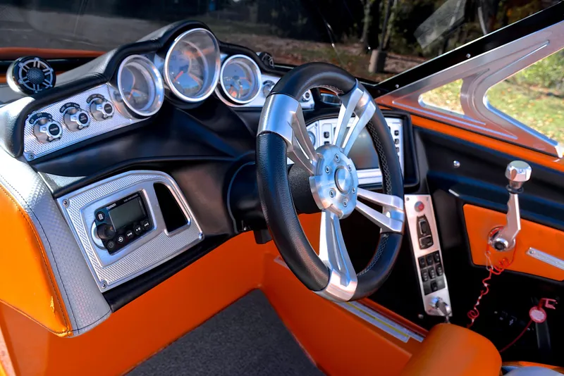 Slide: The Image of 2015 MasterCraft X23 boat dashboard with orange accents and modern controls. - 27