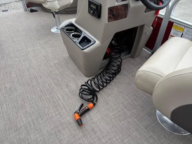 Slide: The Image of 2022 Sun Tracker Bass Buggy 18 DLX interior with coiled hose and cup holders. - 15
