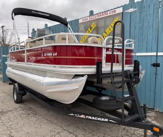 Slide: The Image of 2022 Sun Tracker Bass Buggy 18 DLX pontoon boat on trailer, red and white design. - 2