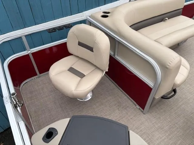 Slide: The Image of 2022 Sun Tracker Bass Buggy 18 DLX pontoon boat interior with beige seating and red paneling. - 24