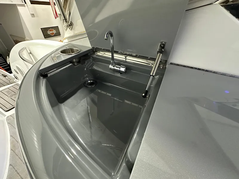 Slide: The Image of 2014 Formula 370 Super Sport boat sink with faucet and storage area. - 6